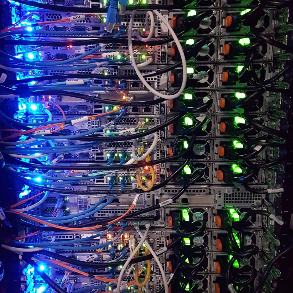 Nærbilde av utallige ledninger koblet til en server på et datasenter.